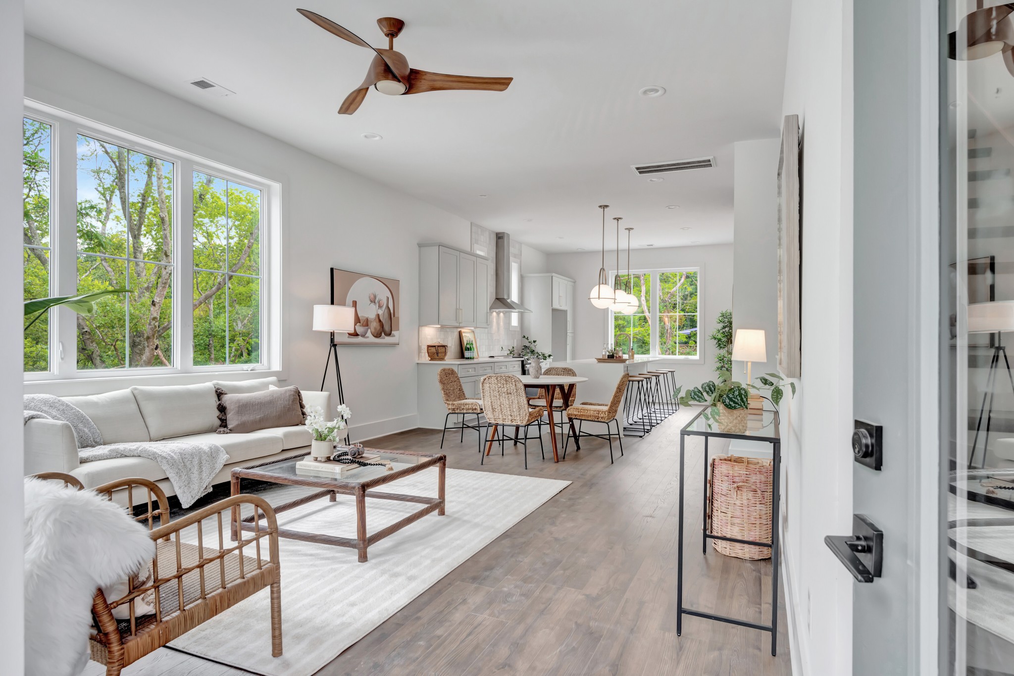 Finished open living, dining, and kitchen interior with large windows and natural light