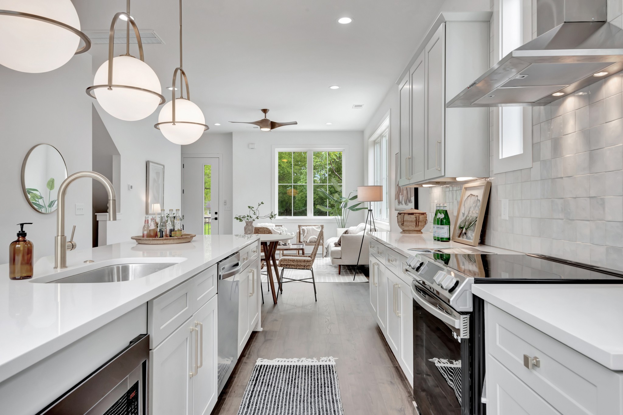 Finished kitchen with white cabinetry, stone counters, and pendant lighting