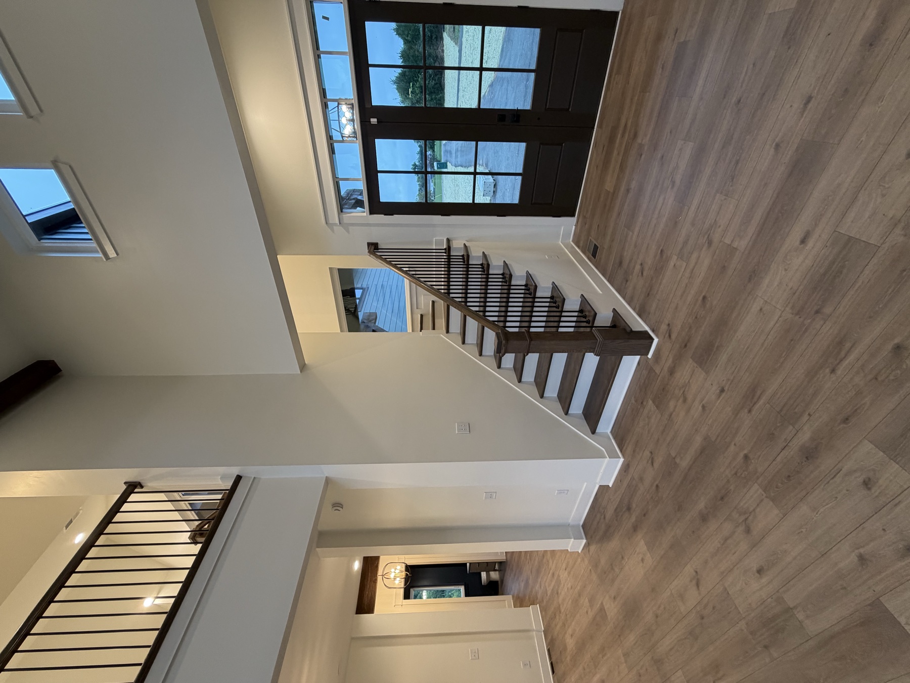 Finished open stair with dark railing in a two story entry