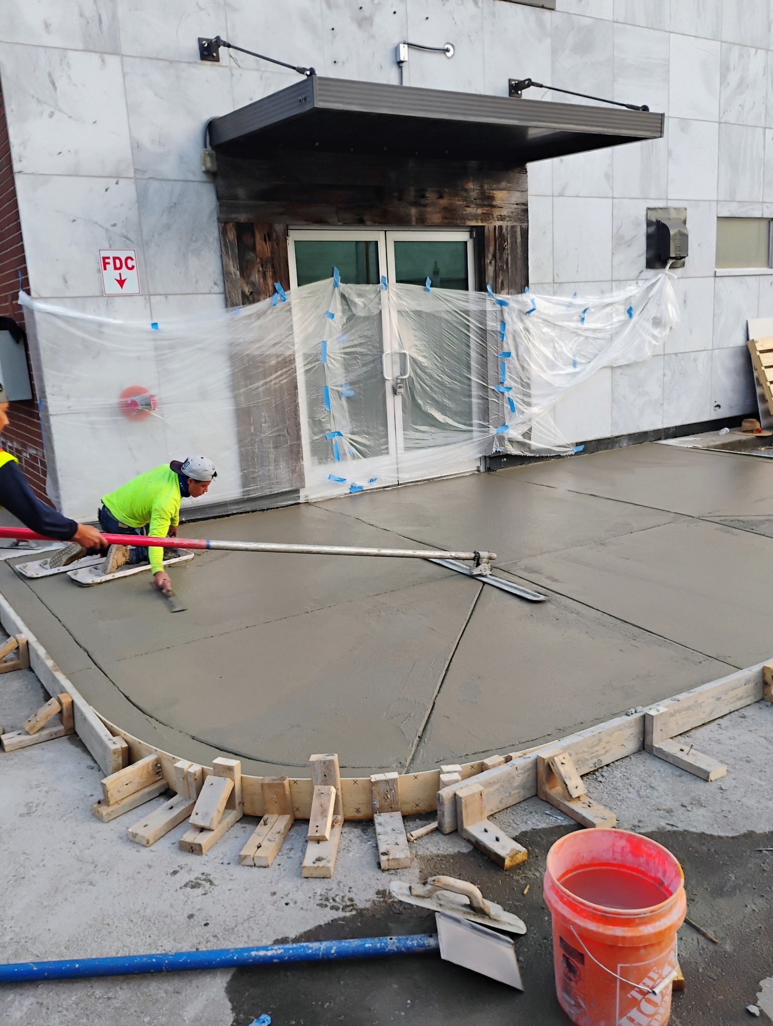 Crew finishing a newly placed concrete entrance