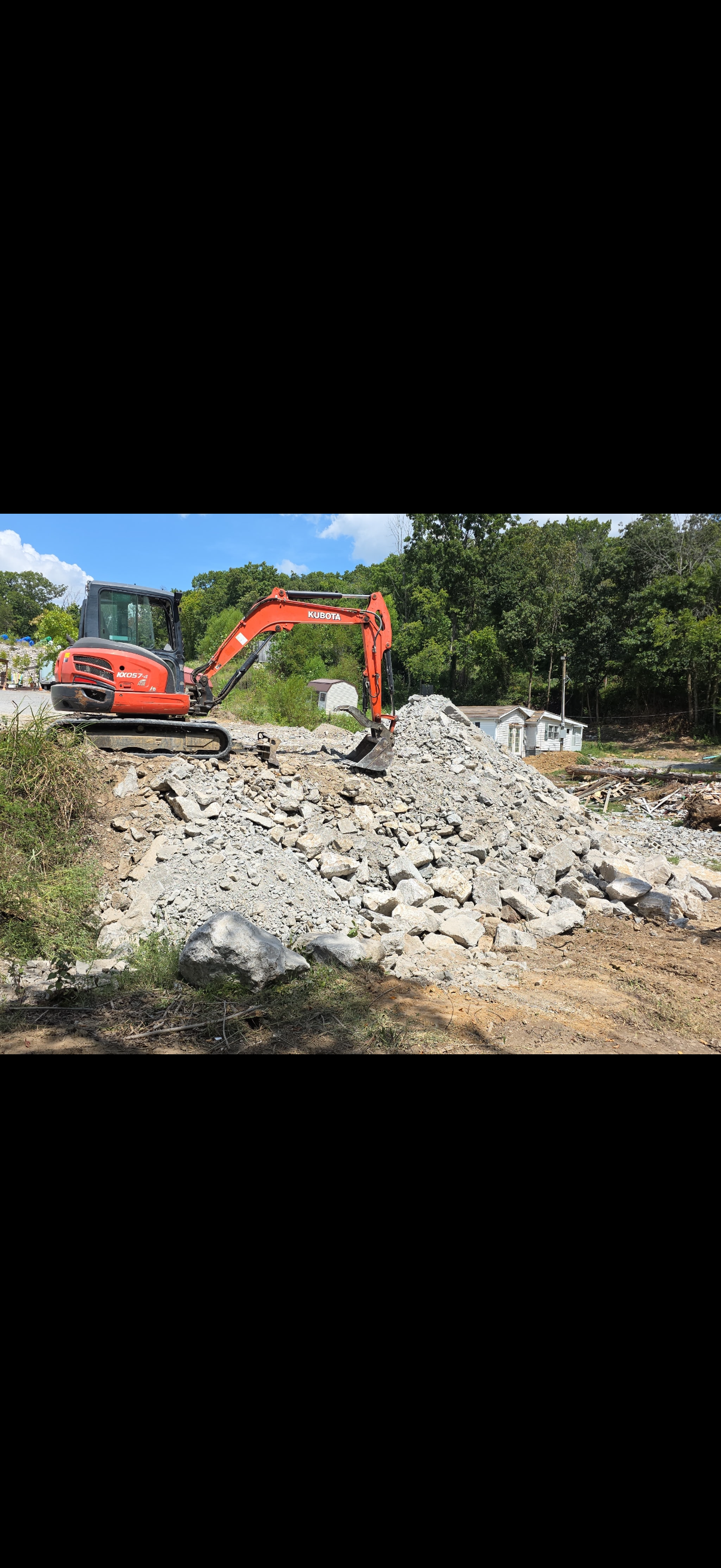 Excavator working through rock on a development site